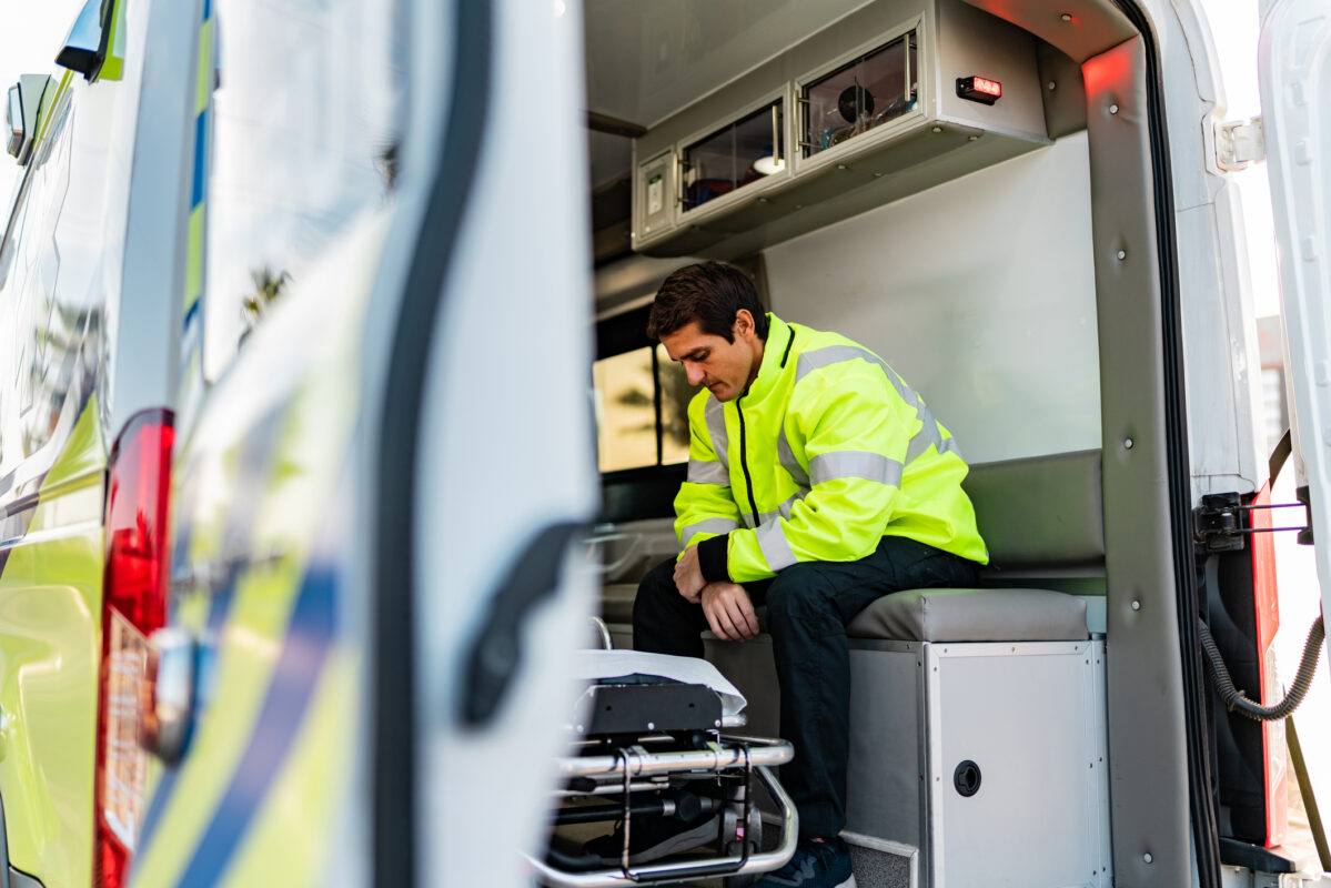 Sad mid adult paramedic man on ambulance